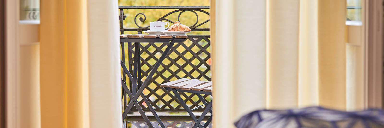 Blick auf Balkon mit Frühstückstisch 1600 x 534